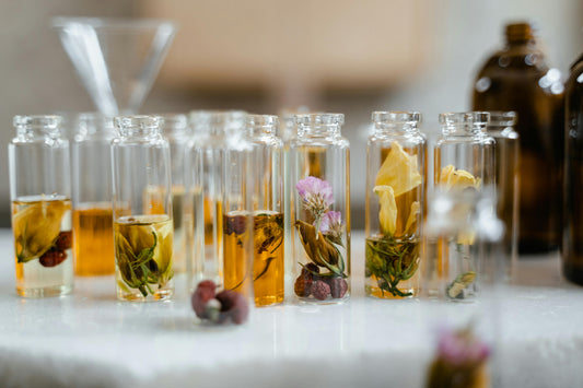 Aromatherapy, small clear glass bottles with amber coloured essential oils and dried flowers in them