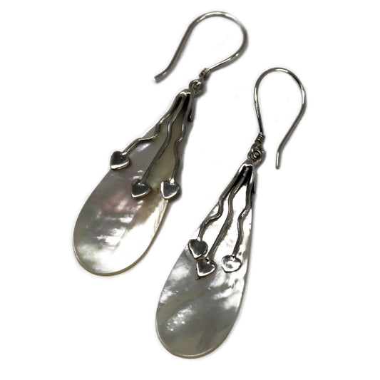 "Long teardrop-shaped mother of pearl earrings with three trailing silver hearts, handcrafted in Bali."