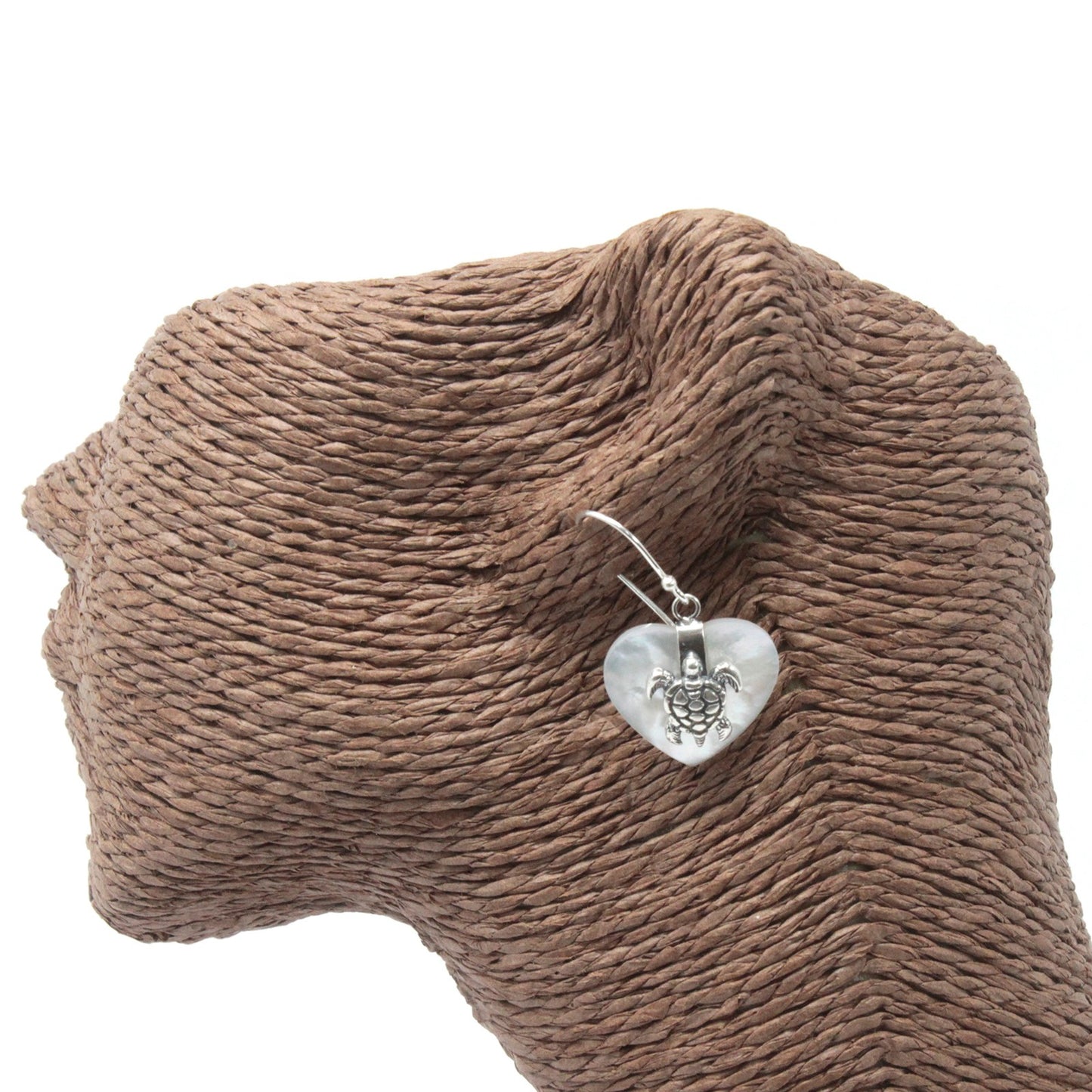 "Heart-shaped mother of pearl earrings with ornate sterling silver sea turtle overlay, handcrafted in Bali."