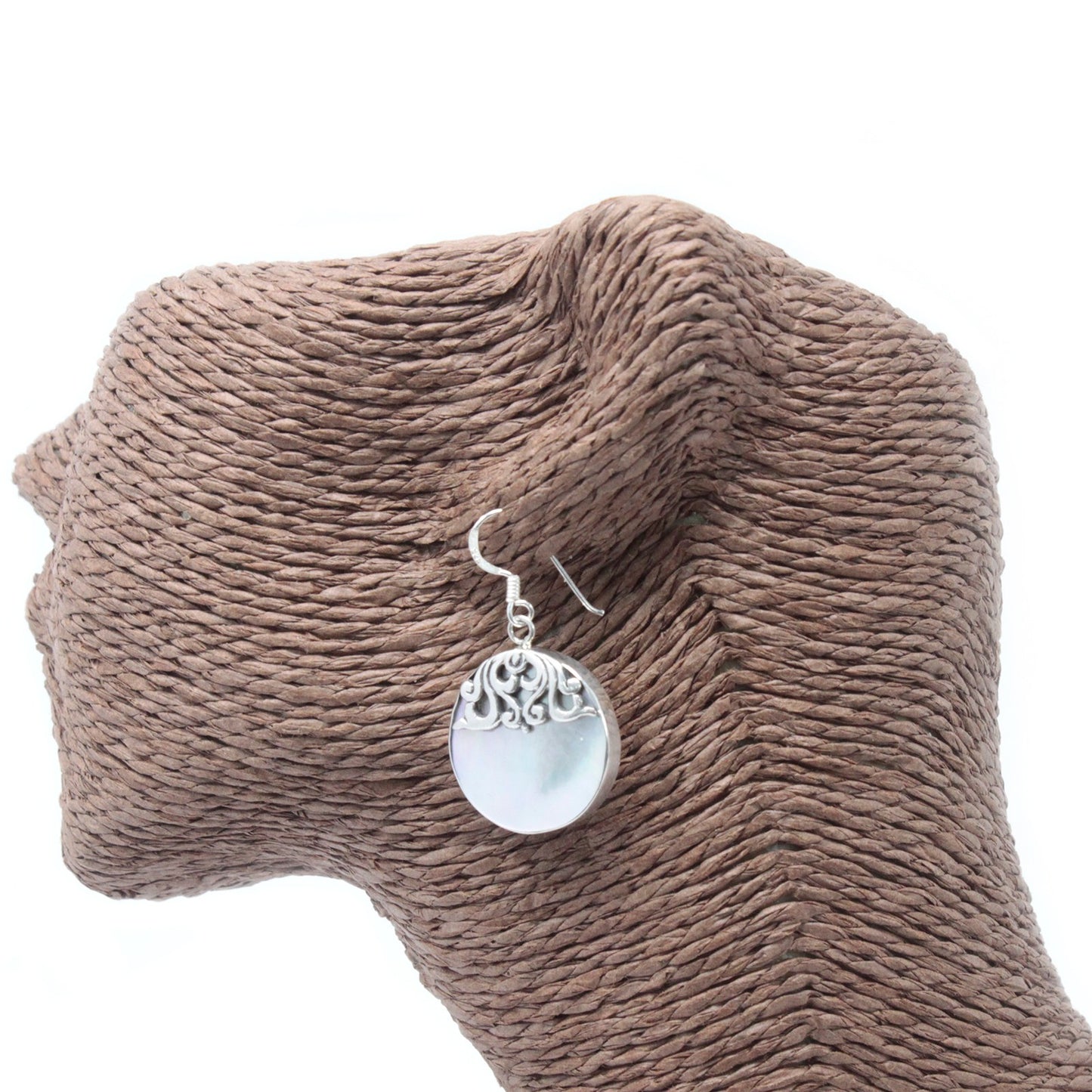 "Round mother of pearl earrings with ornate sterling silver swirl overlay and silver frame, handmade in Bali."