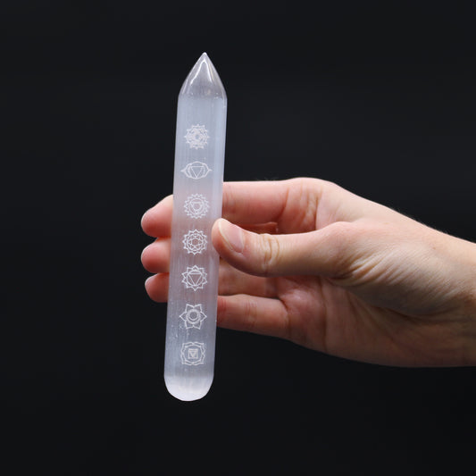 Polished Selenite wand engraved with 7 chakra symbols and a pointed tip, ideal for energy alignment, chakra healing, and spiritual cleansing rituals.