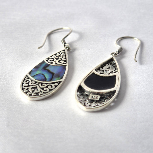"Teardrop-shaped silver earrings with intricate filigree design and abalone shell inlay, handmade in Bali."