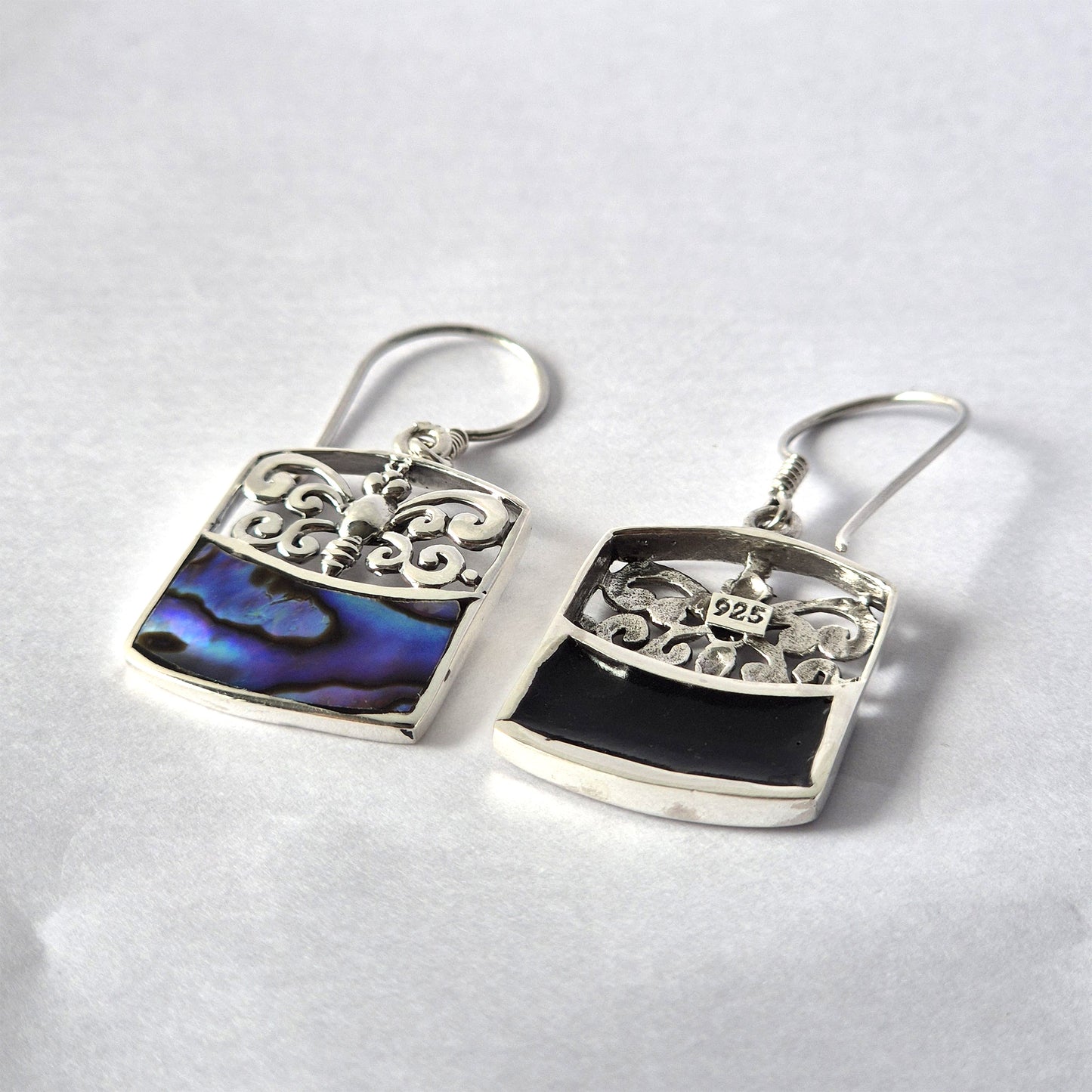 Handmade sterling silver earrings with dragonfly filigree and iridescent abalone shell inlay, displayed on a white background