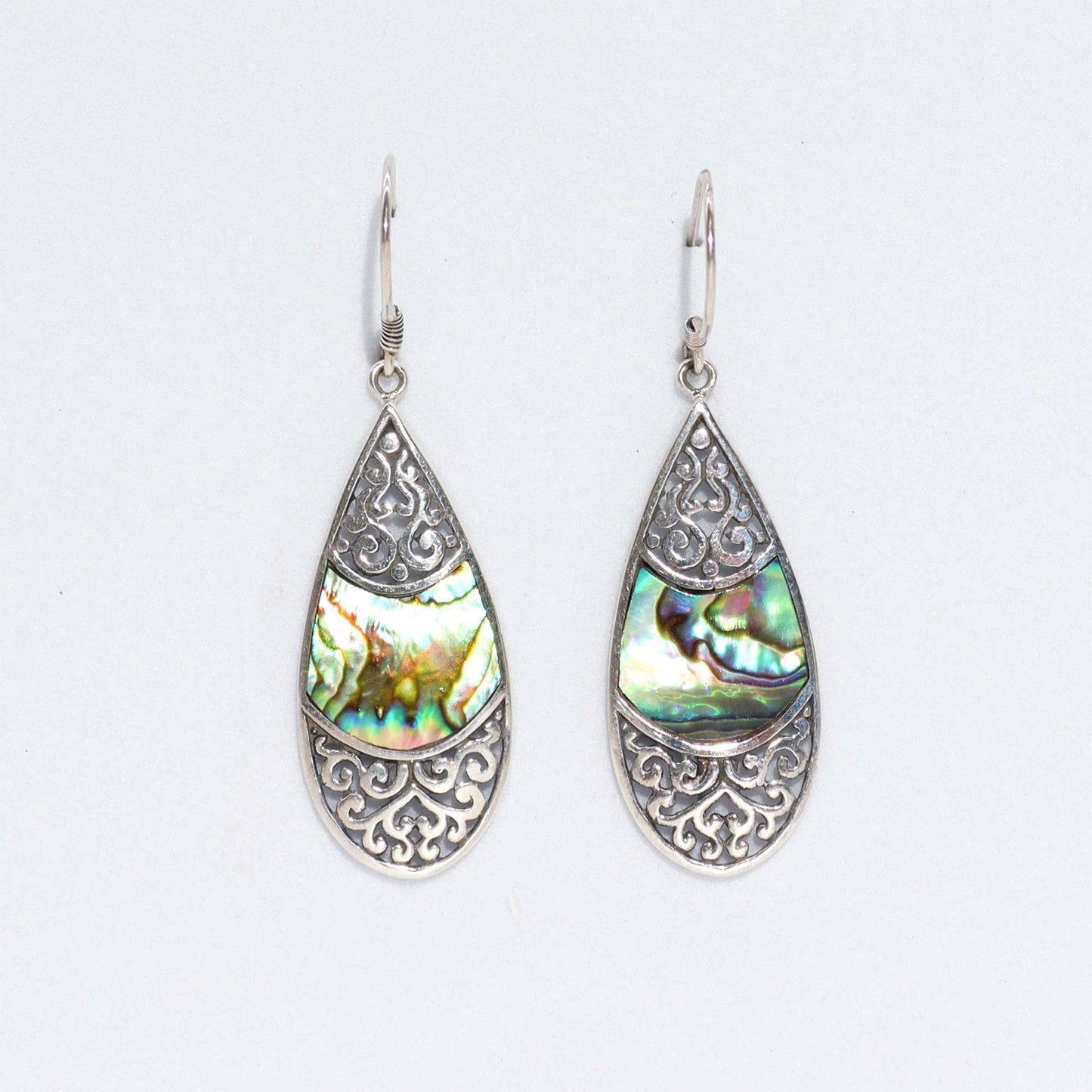 "Teardrop-shaped silver earrings with intricate filigree design and abalone shell inlay, handmade in Bali."