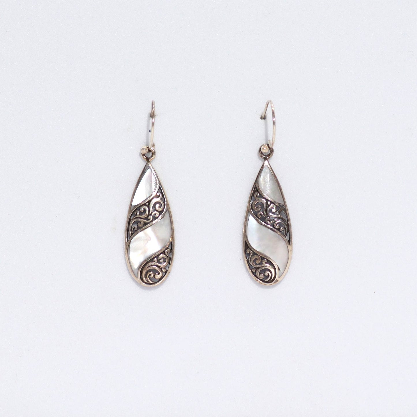 "Teardrop earrings with mother of pearl and swirling sterling silver inlay, handcrafted in Bali."