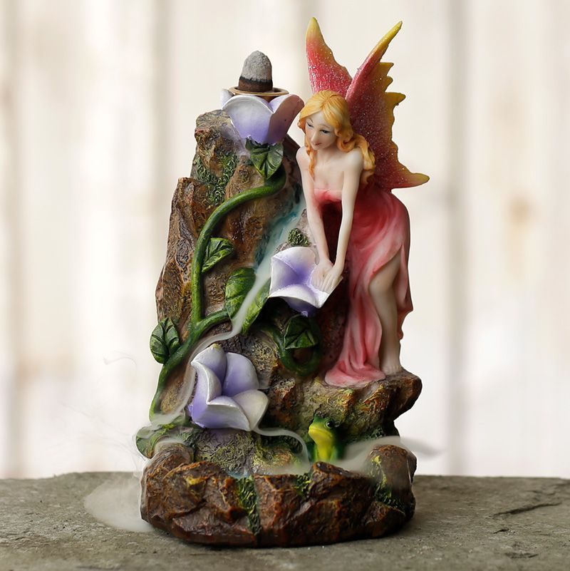 Fairy garden-themed backflow incense burner with flowing smoke, floral accents, and magical styling for fantasy-inspired interiors.