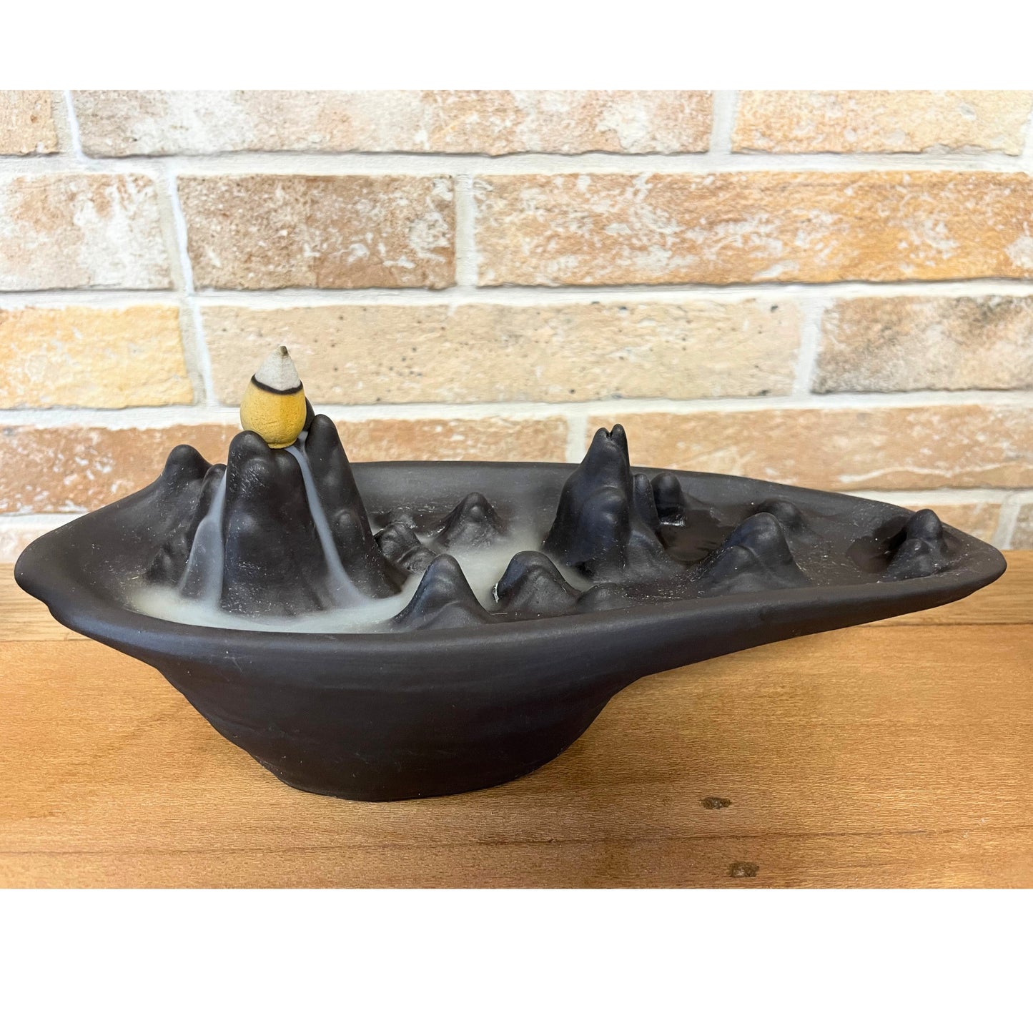 Mountain scape backflow incense burner with layered peaks and smoke waterfall effect. Nature-inspired spiritual décor piece.