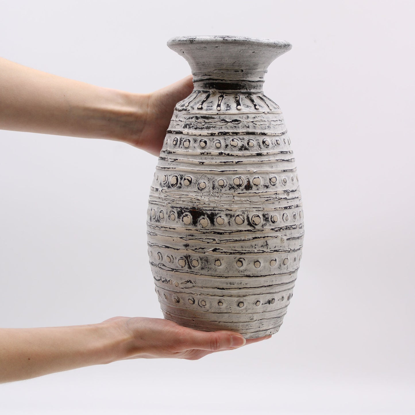 Cream terracotta vase with classic silhouette and carved textured bands – handmade in Lombok, ideal for dry arrangements or decorative display.