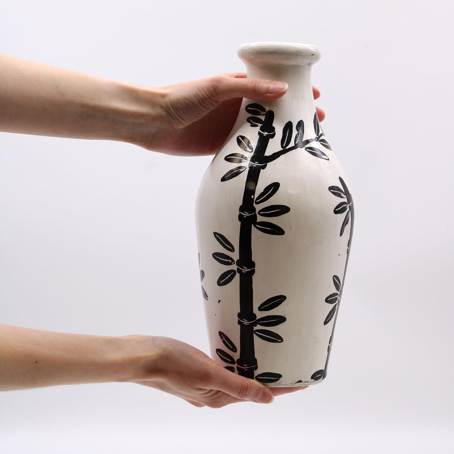 Natural terracotta vase with curved shape and black bamboo design – handcrafted in Lombok for dried flowers or decorative use.