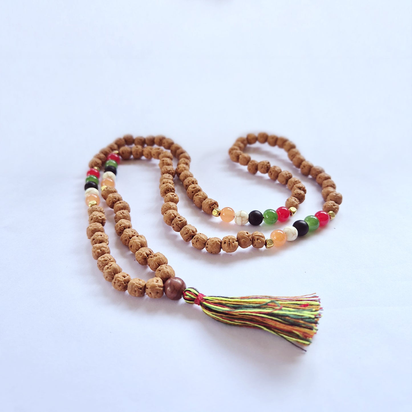 "Five Element Talent Mala with Rudraksha and multicoloured earth-tone beads in white, black, grey, red, green and orange, with a multicoloured tassel."