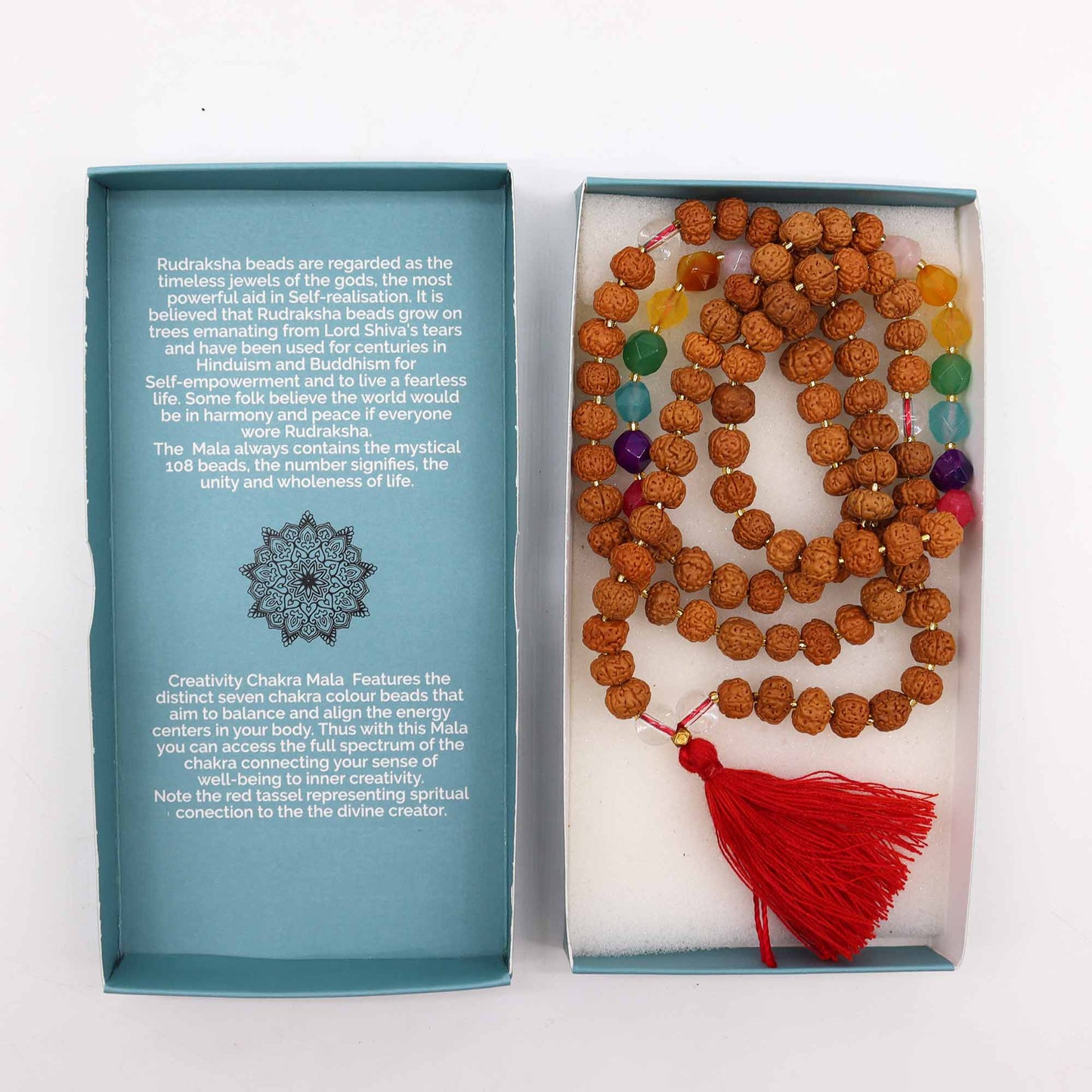 "Creativity Chakra Mala necklace with Rudraksha beads and seven chakra-coloured glass beads, finished with a bold red tassel and gift box."