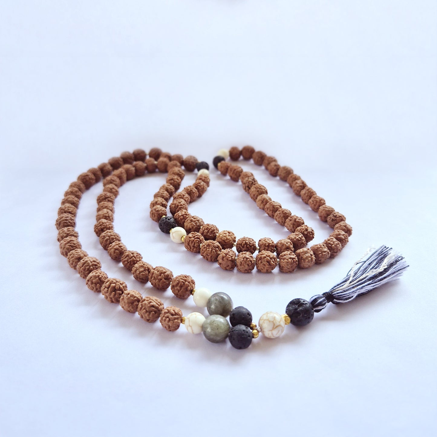 "Confidence Mala necklace made with Rudraksha and coloured glass beads, featuring a black and white tassel."
