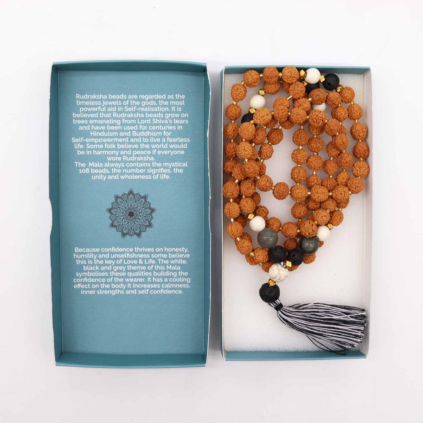 "Confidence Mala necklace made with Rudraksha and coloured glass beads, featuring a black and white tassel, displayed beside blue spiritual gift box."