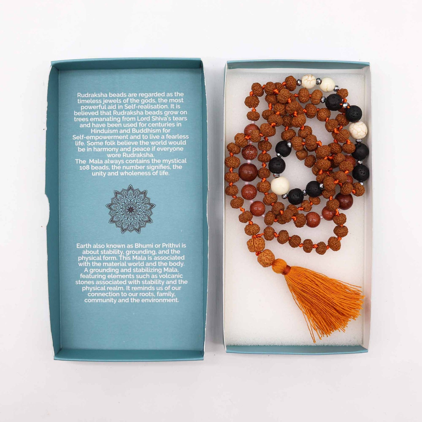 "Earth Element Mala necklace with Rudraksha, volcanic stones, warm red and cream-toned accents, and ochre tassel, shown with gift box."