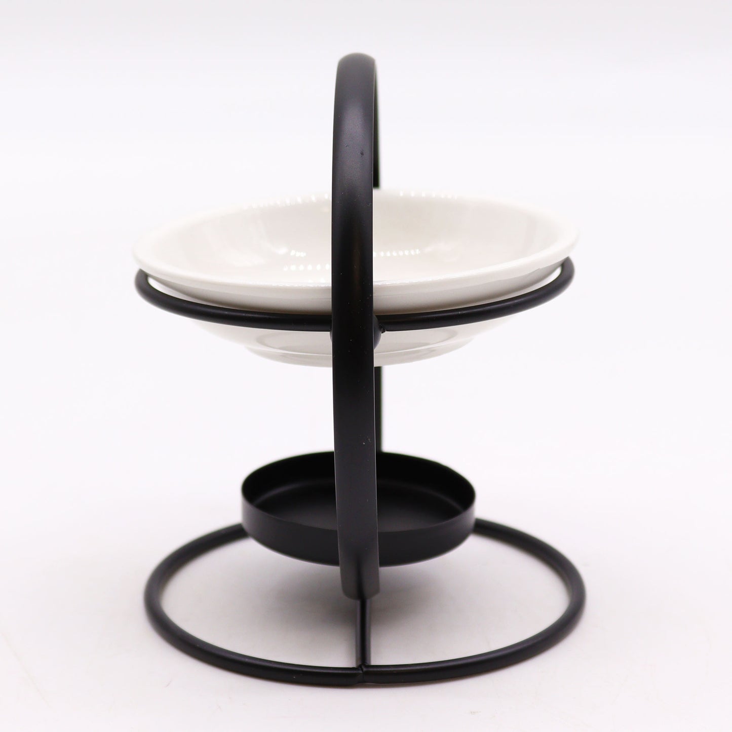 Modern oil burner with white ceramic dish suspended in a black metal hoop stand, designed for essential oils and tealights