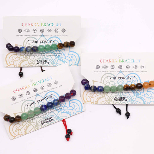 Chakra string bracelet with 21 gemstone beads and "I am creative" affirmation on an adjustable cotton cord.