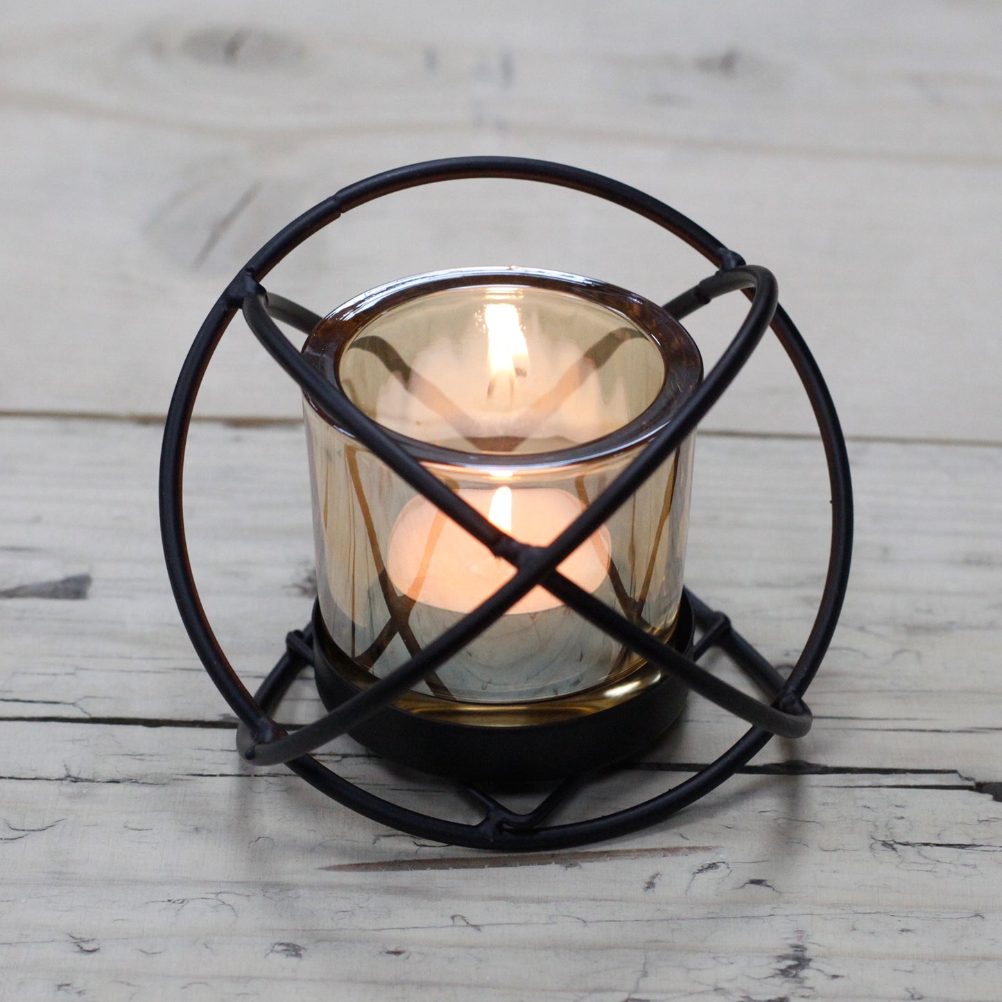 Orb-shaped iron candle holder with amber glass votive – single tealight design