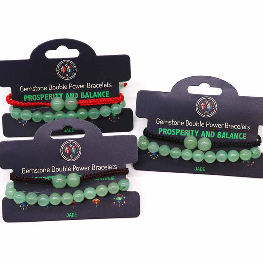 Jade gemstone bracelet with two large beads and “Prosperity and balance” affirmation on adjustable elastic cord.