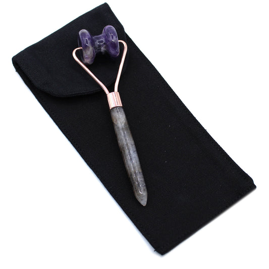 Amethyst crystal jawline roller with curved design for calming, targeted facial massage.