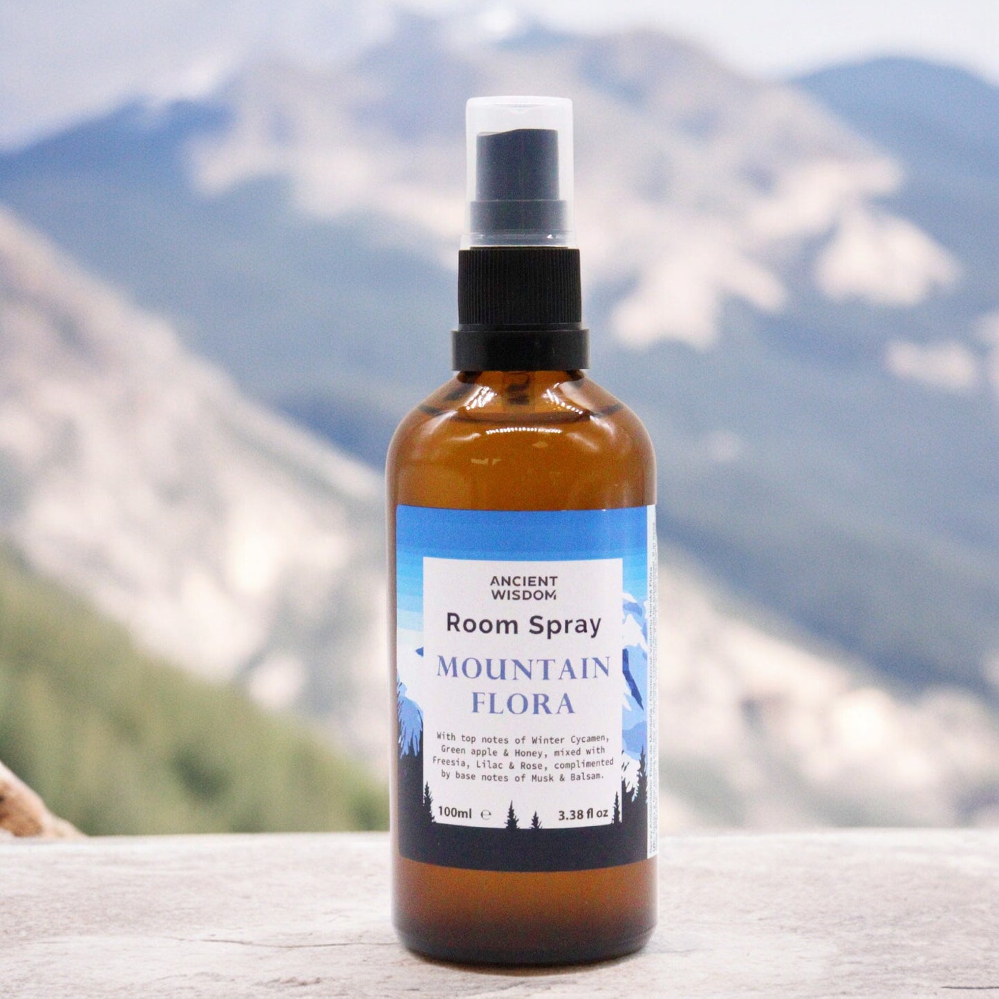 Amber glass bottle of Mountain Flora room spray – 100ml, featuring floral, green, and musky fragrance notes.