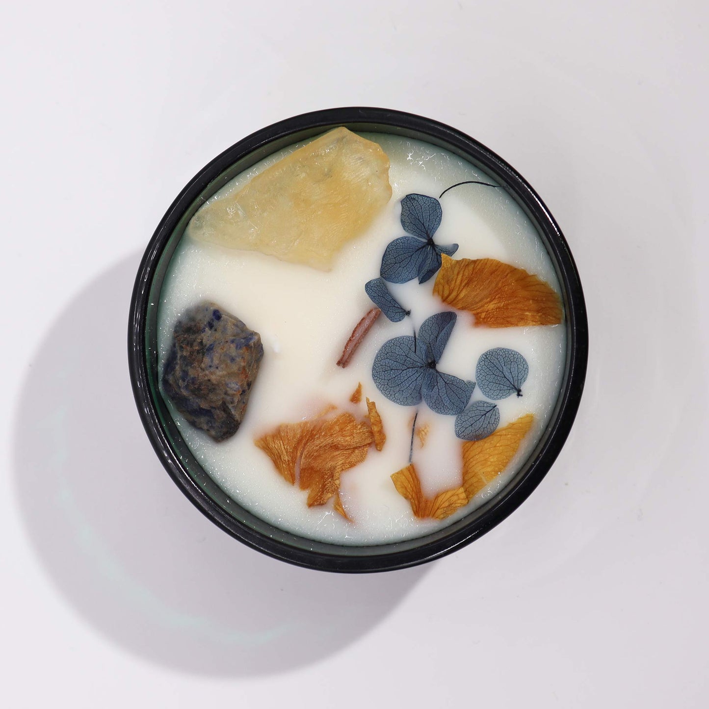 Hop Hare The Sun crystal candle with citrine, sodalite, dried flowers, and tarot card in dark green jar