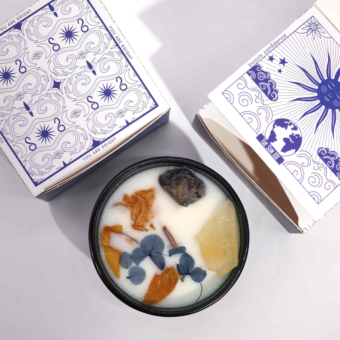Hop Hare The Sun crystal candle with citrine, sodalite, dried flowers, and tarot card in dark green jar