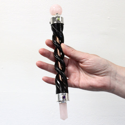 Spiral-carved wooden healing wand with copper core, rose quartz point and sphere, and gemstones. A tool for love, compassion, and energy balancing.