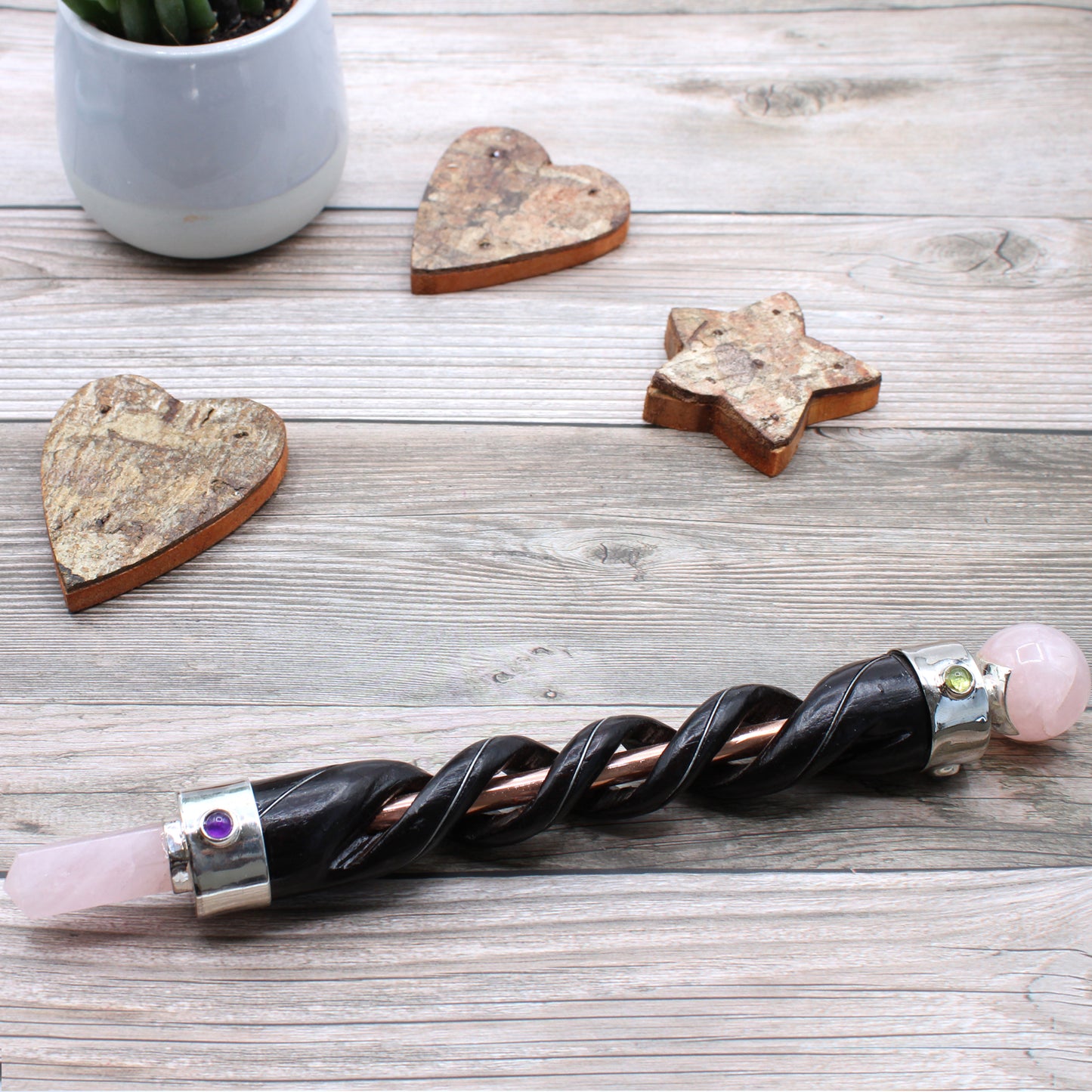 Spiral-carved wooden healing wand with copper core, rose quartz point and sphere, and gemstones. A tool for love, compassion, and energy balancing.