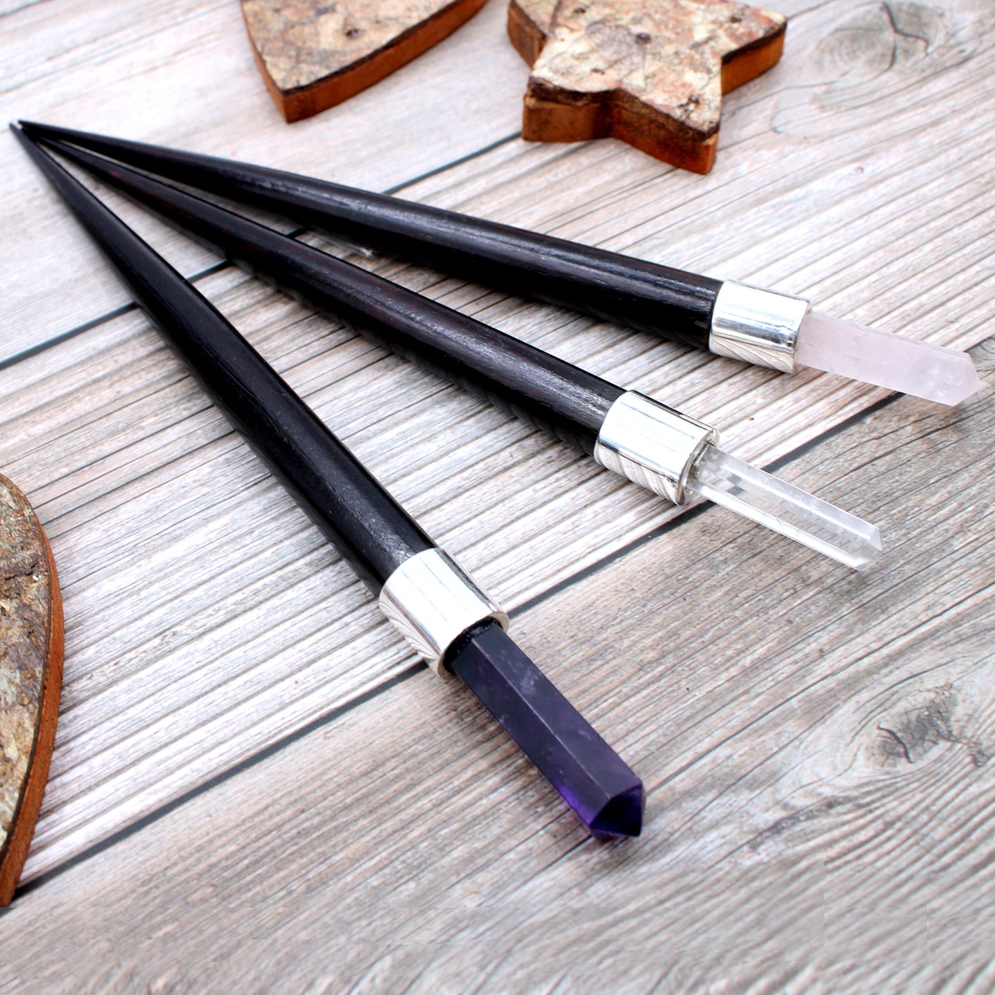 Set of 3 healing wands with pointed crystal tips: amethyst, rose quartz, and rock quartz. Featuring wooden handles and silver caps for energy work and meditation.