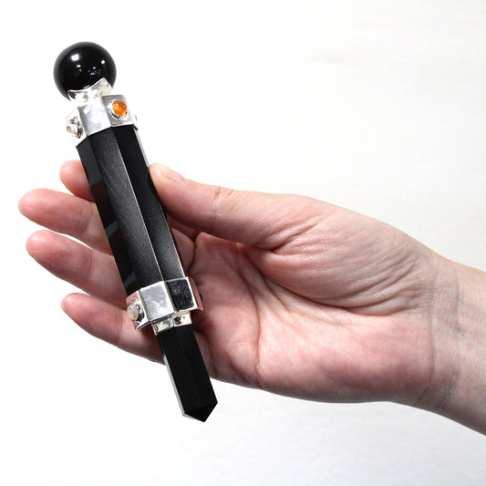 Hexagonal black agate healing wand with pointed tip, rounded sphere end, and gemstone accents. Designed for grounding, protection, and energy balancing.