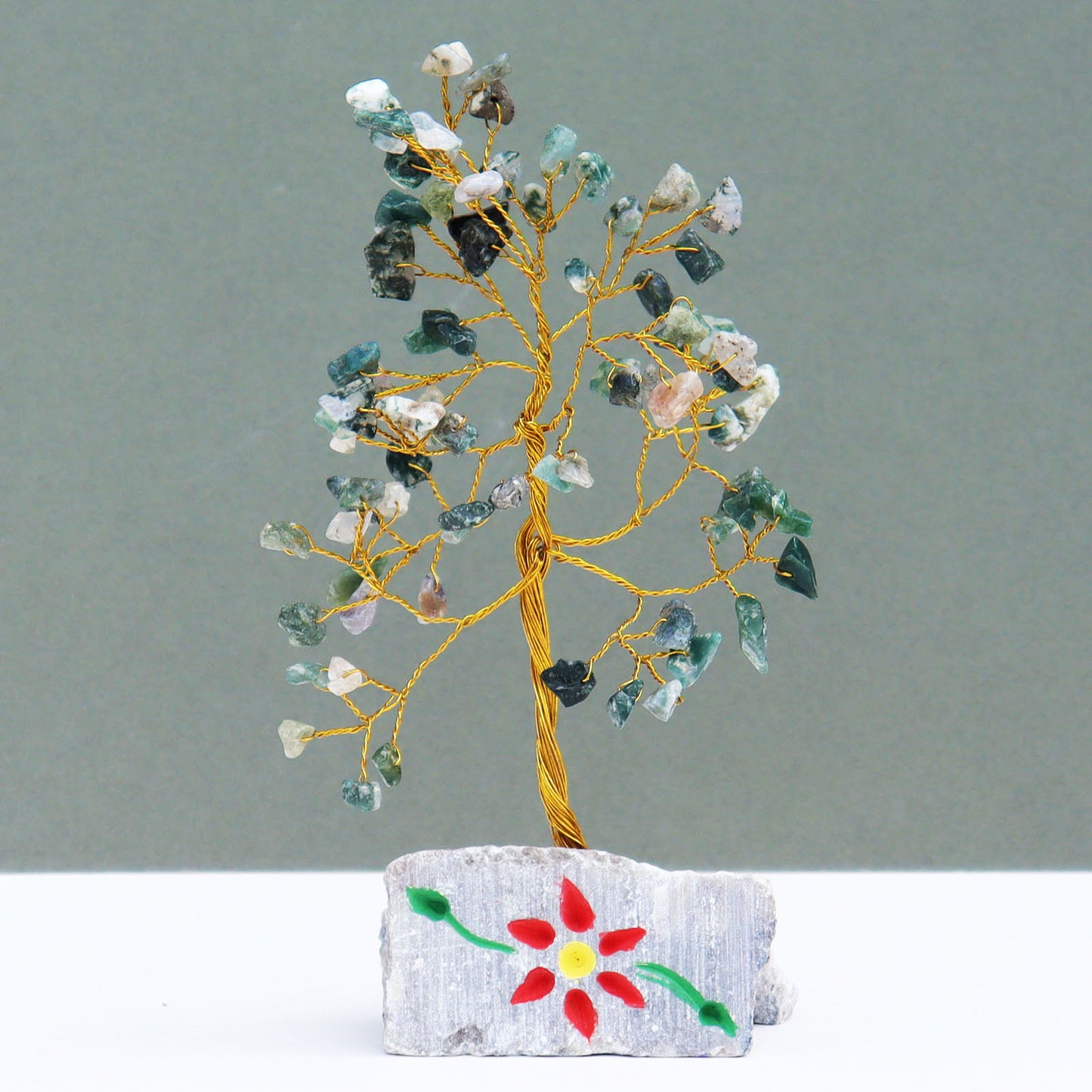 Moss agate tree with 80 natural green gemstone chips on flexible silver wire branches, displayed on a carved and hand-painted stone base from India.