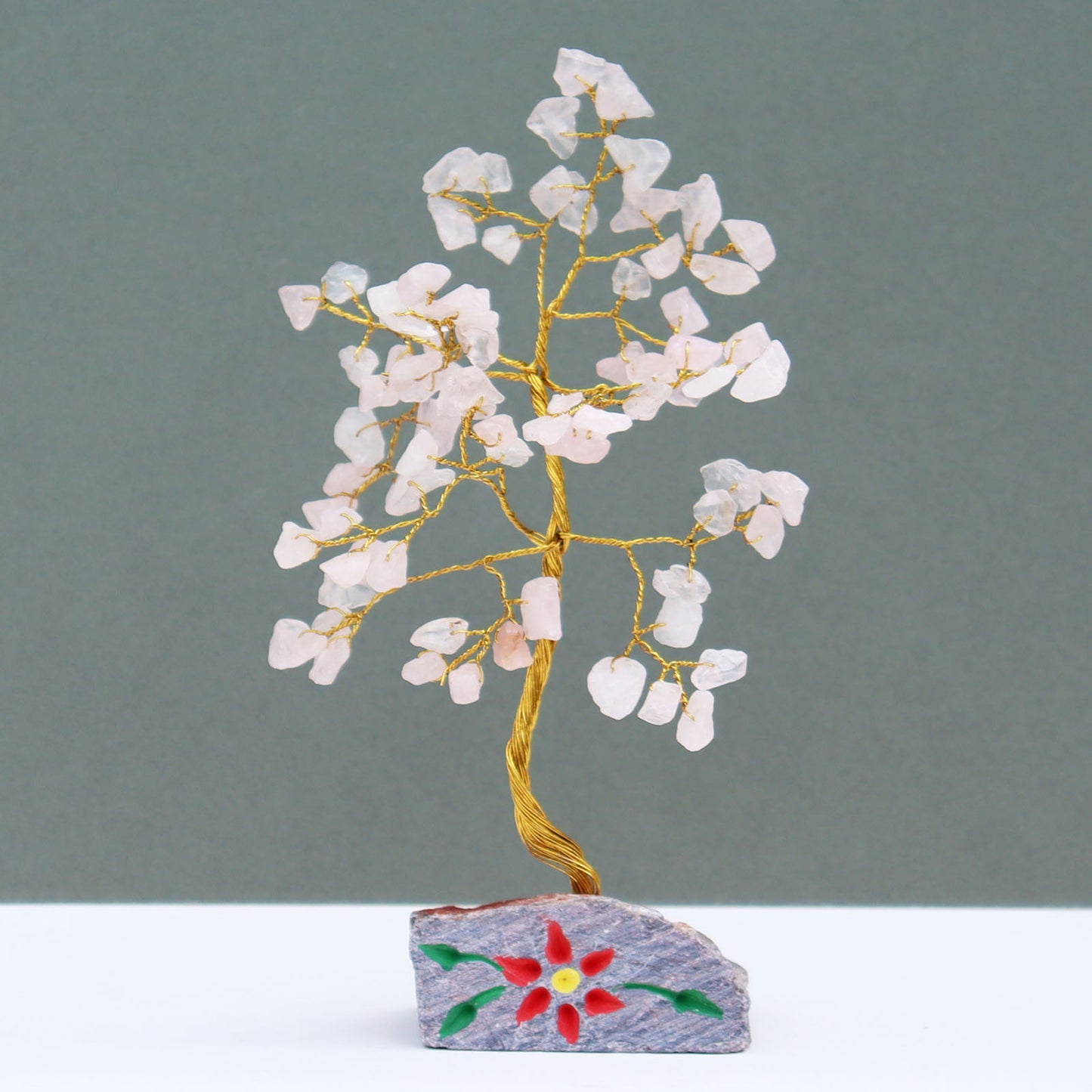 Rose quartz tree with 80 pale pink gemstone chips on silver wire branches, mounted on a hand-carved and painted natural stone base crafted in India.