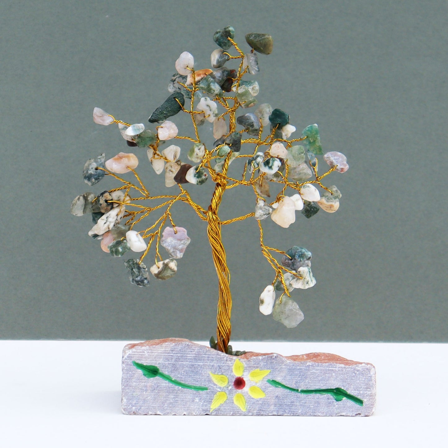 Tree agate crystal tree with 80 green-white chips on silver branches, set into a hand-carved and painted stone base with natural details and Indian craftsmanship.