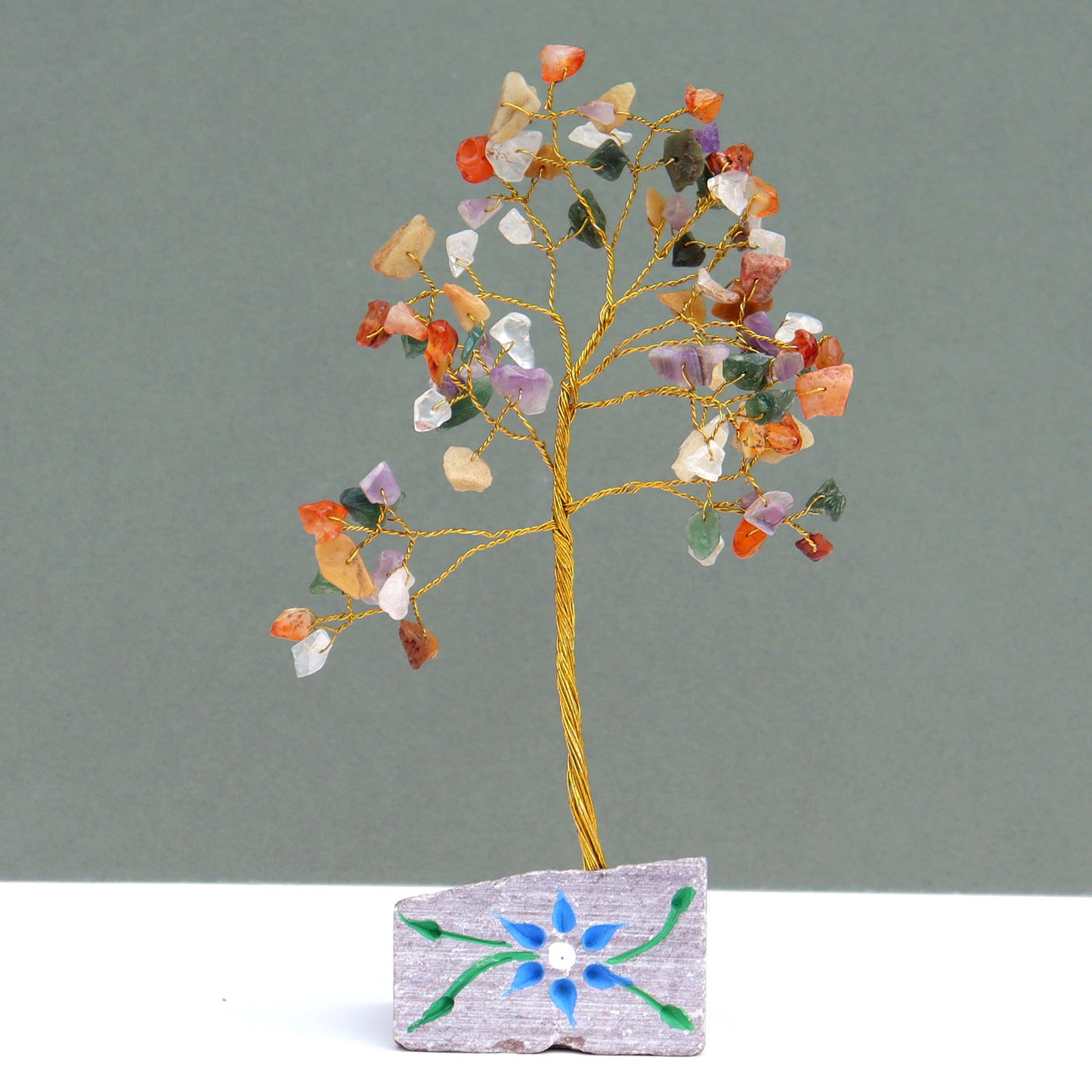 Mixed crystal tree with 80 multicolored gemstone chips on silver wire branches, mounted on a hand-carved and painted natural stone base from India.