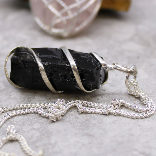 Raw Black Onyx stone pendant wrapped in silver wire on silver-plated chain