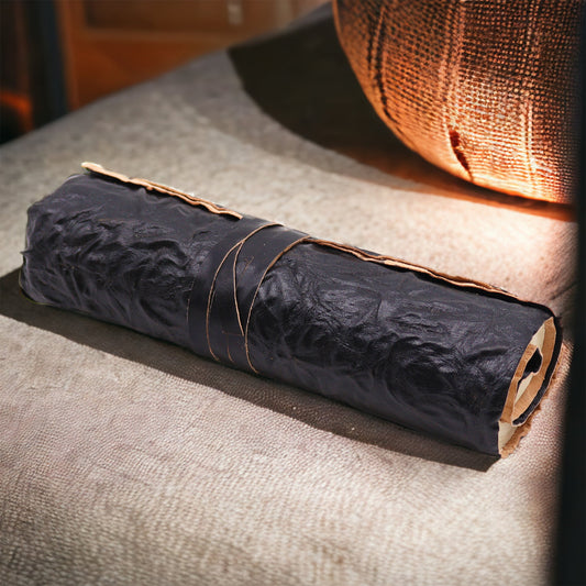Rolled black leather travel notebook with plain ivory pages, unrolled and ready for writing.
