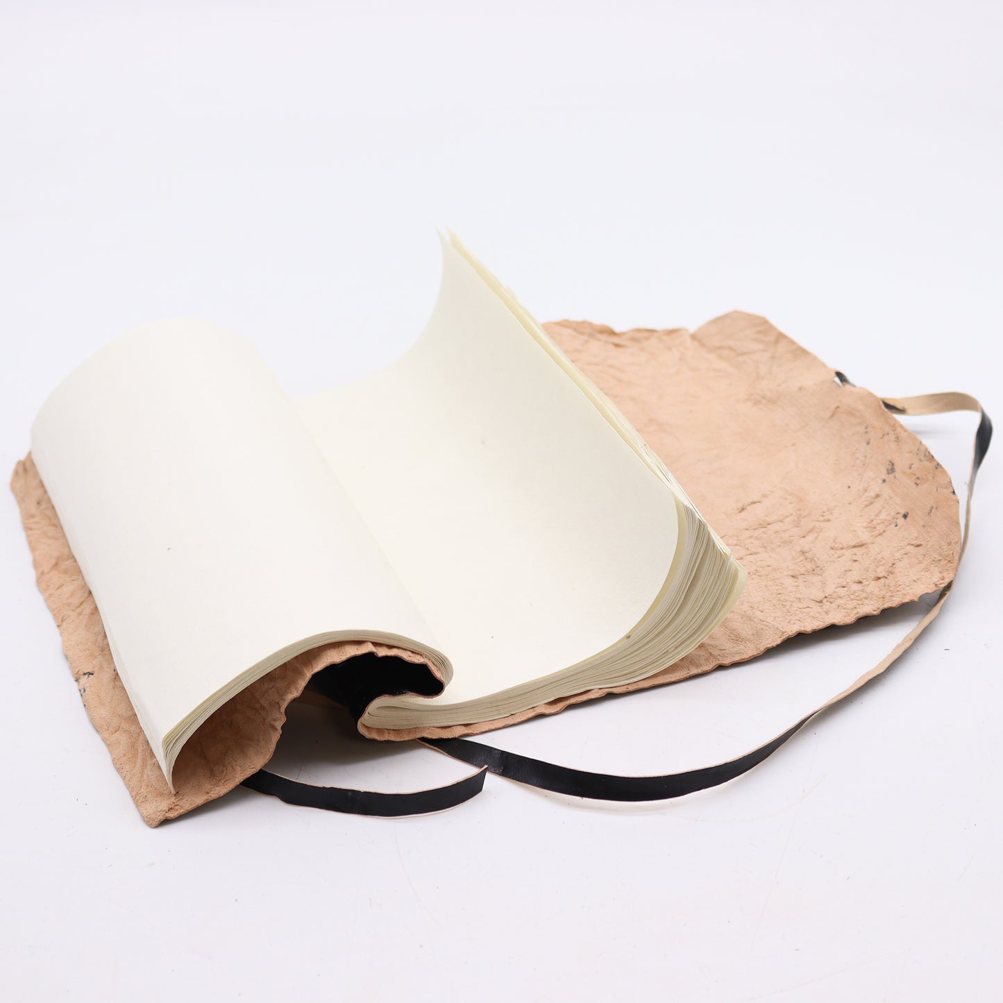 Rolled black leather travel notebook with plain ivory pages, unrolled and ready for writing.