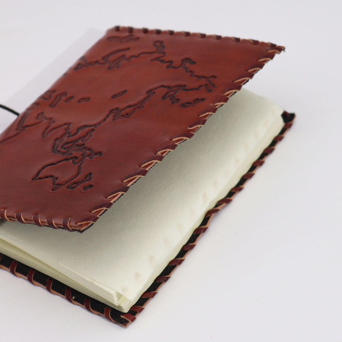Red leather travel journal with world map embossing and wrap closure – 96 pages