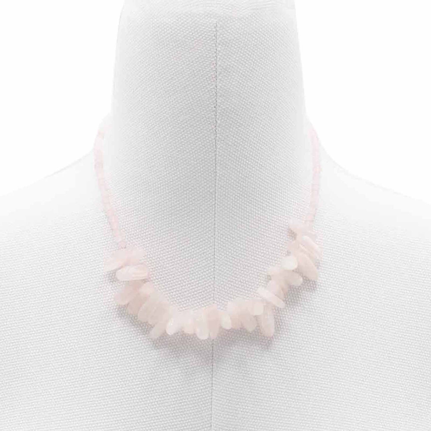 "Longstone Gem Necklace with rose quartz gemstone chips and round beads in soft blushing pink, displayed on a jewellery bust."