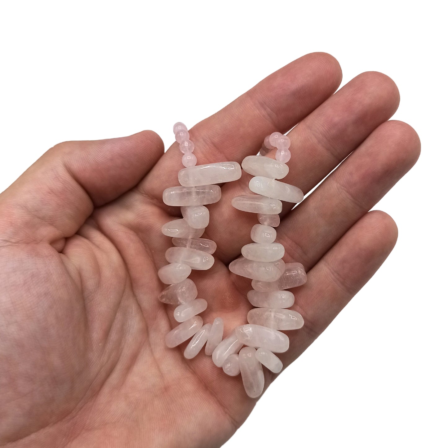 "Longstone Gem Necklace with rose quartz gemstone chips and round beads in soft blushing pink, displayed on a hand."