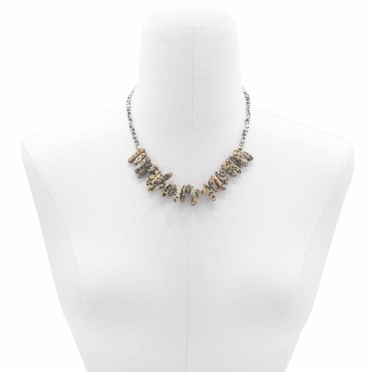 "Longstone Gem Necklace with Dalmatian Stone gemstone chips and round beads featuring natural black spots on a cream base, styled on a white display stand."