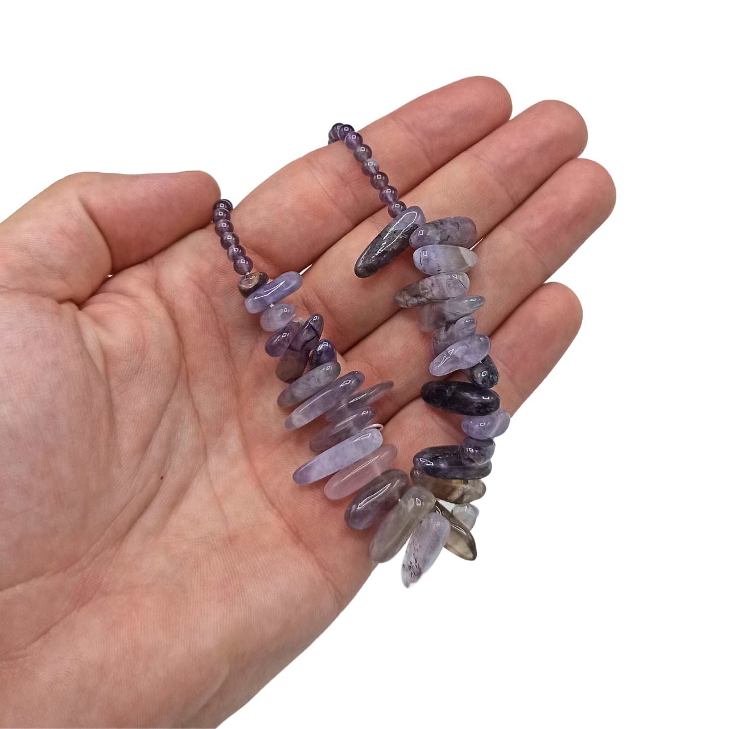"Longstone Gem Necklace with natural amethyst gemstone chips and round accents in rich purple, displayed on a hand."