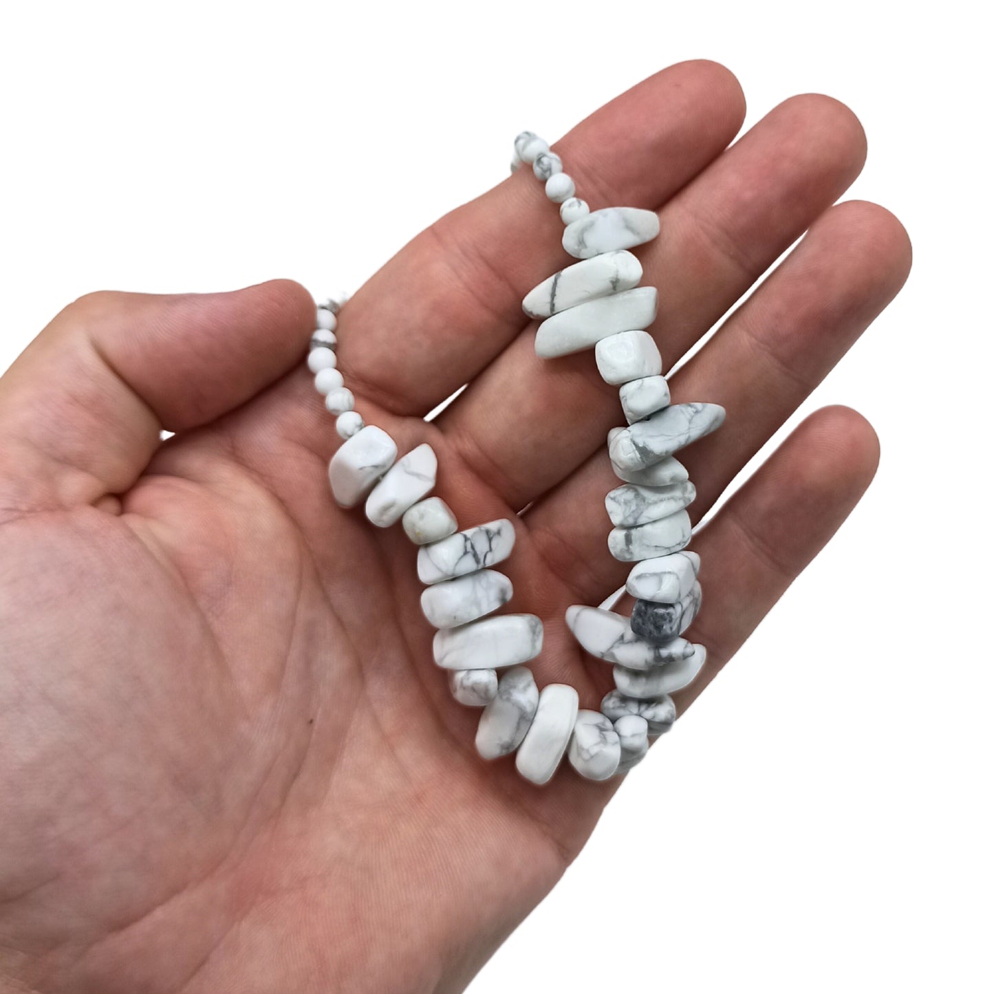 "Longstone Gem Necklace with natural white jasper gemstone chips and round beads, displayed on a hand."