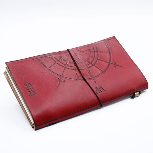 Red leather journal embossed with 'The Adventure Begins' and travel-themed stamps