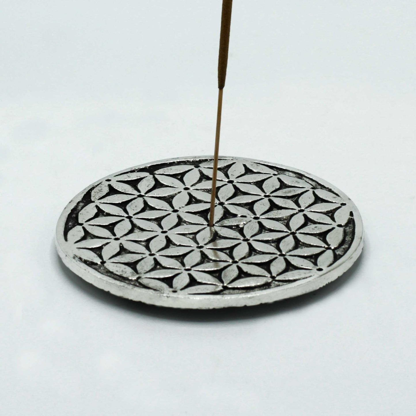 Polished aluminium round incense holder with Flower of Life pattern, 11cm diameter. Ideal for burning incense sticks or cones in spiritual settings.