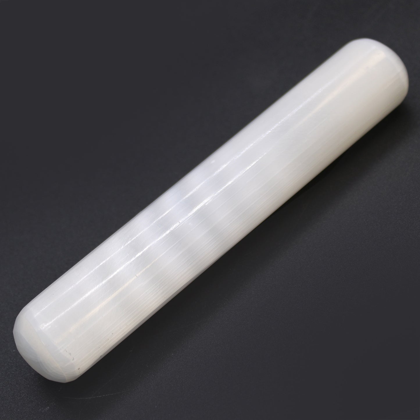 Polished Selenite wand with double rounded ends and smooth cylindrical body, hand-carved from Moroccan crystal for reiki, massage, and chakra balancing.