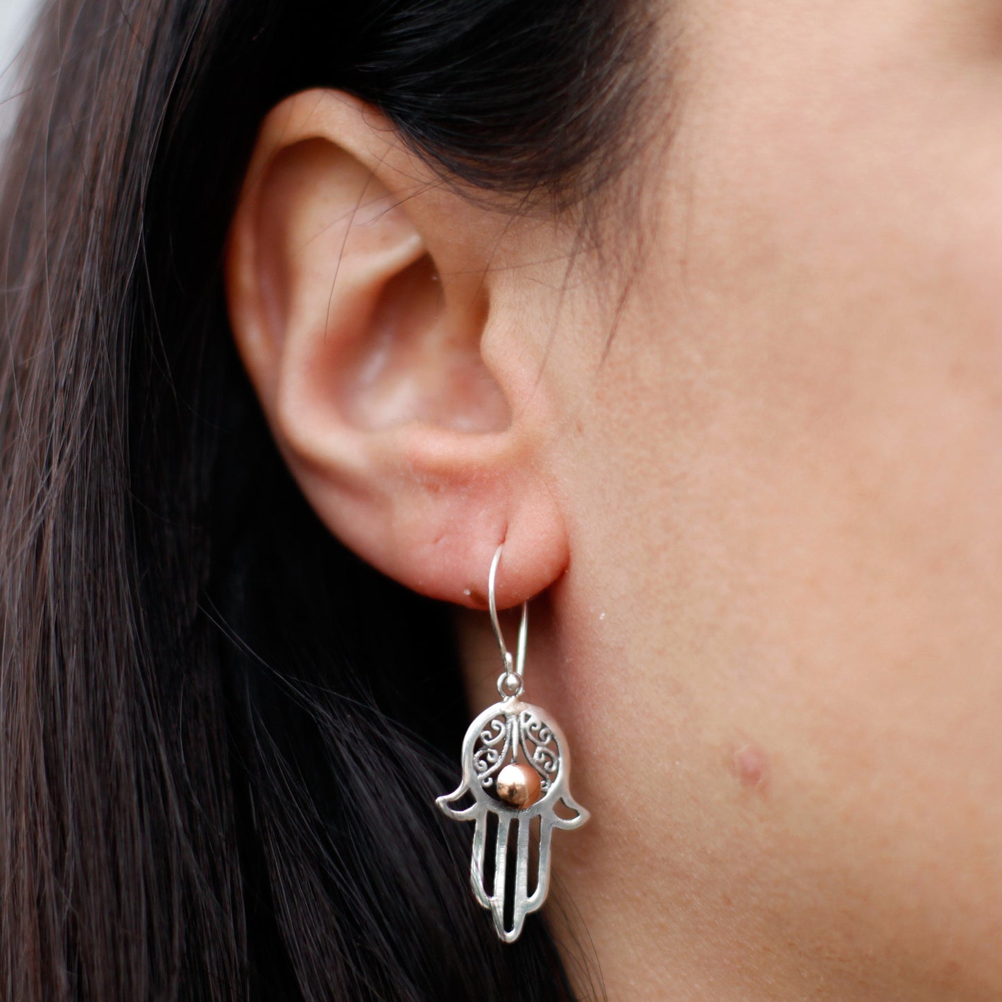 "Hamsa hand earrings in sterling silver with filigree detail and central 18k gold accent, handcrafted in Indonesia."