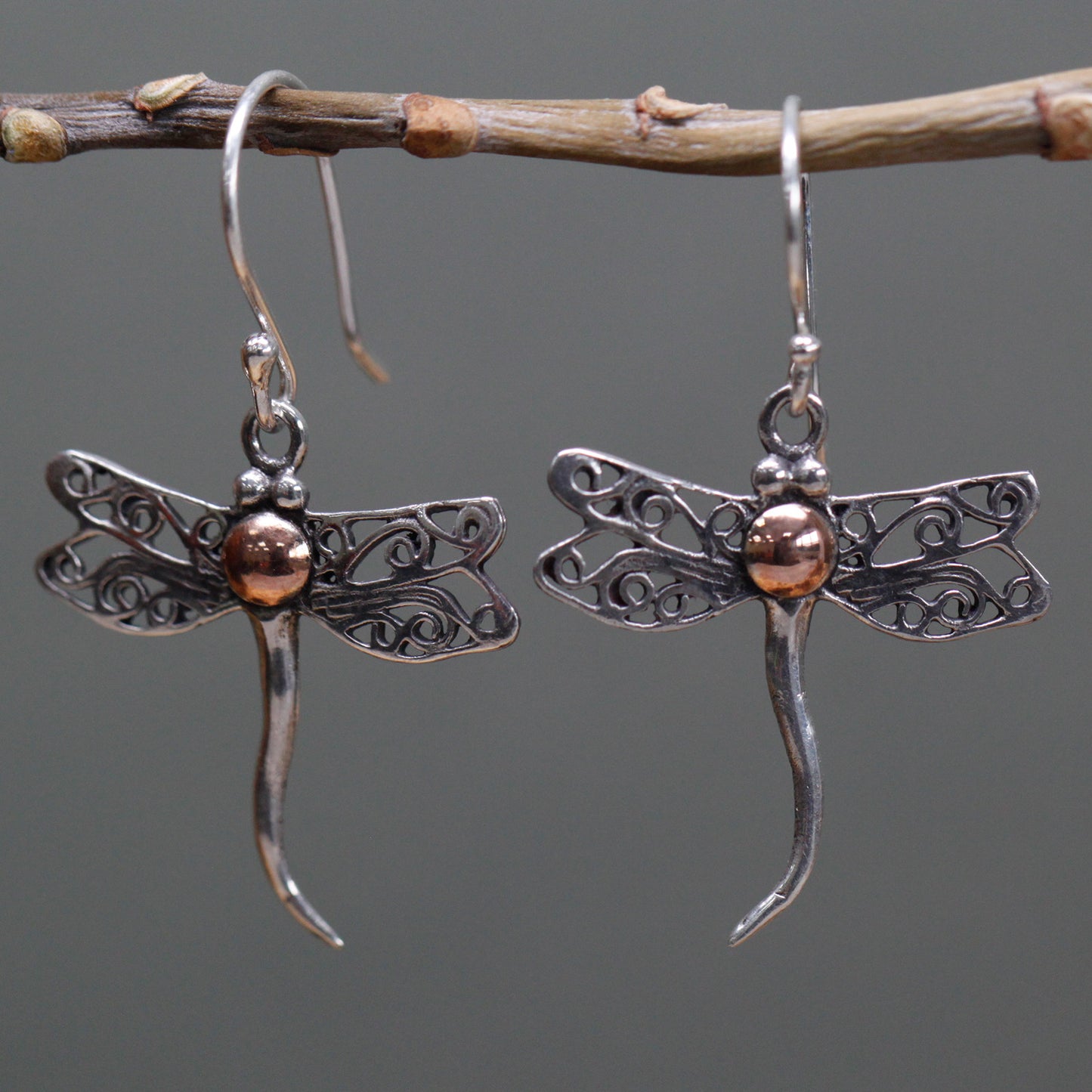 "Dragonfly-shaped sterling silver earrings with filigree wings and 18k gold body detail, handcrafted in Indonesia."