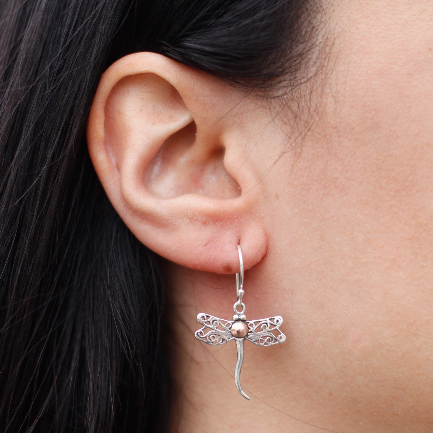 "Dragonfly-shaped sterling silver earrings with filigree wings and 18k gold body detail, handcrafted in Indonesia."