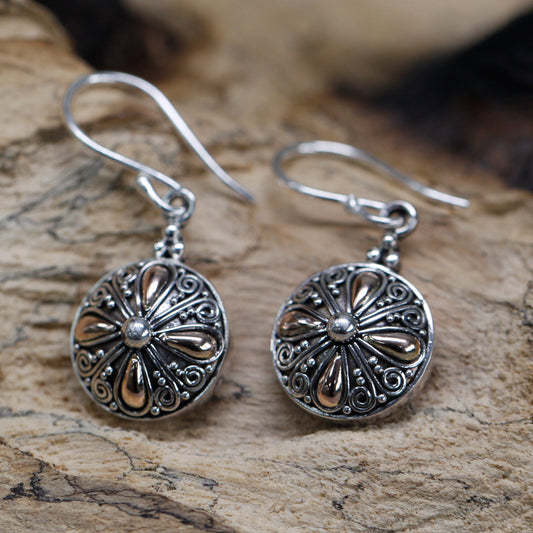 "Round sterling silver earrings with 18k gold teardrop accents and ornate scrollwork, handcrafted in Indonesia."